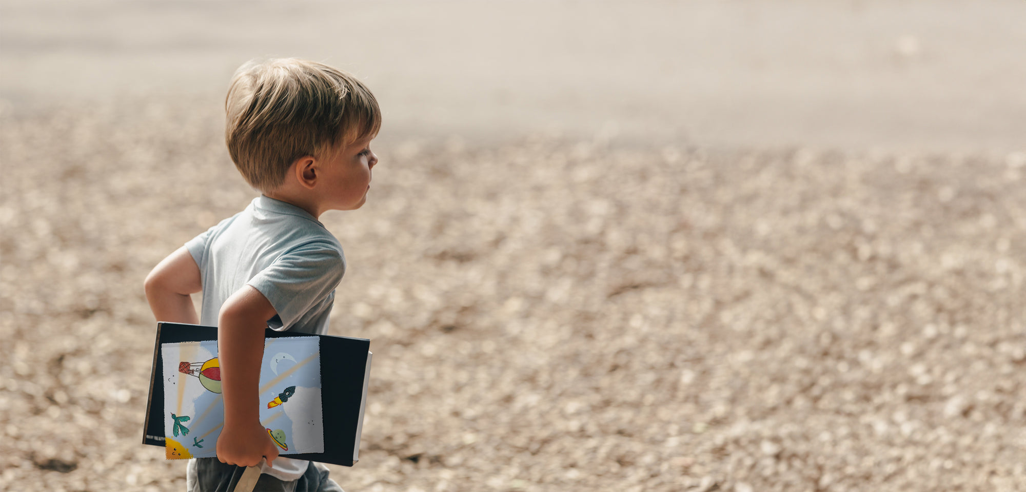 Boy running on beach with adventure book in his hand