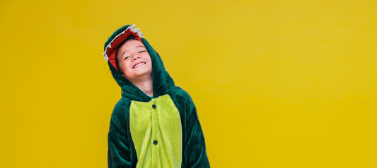 child smiling in a dinosaur costume